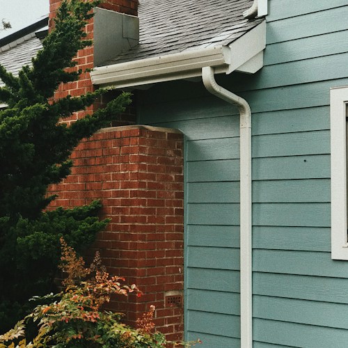 Gutter system on a blue house, downspout and fascia detail