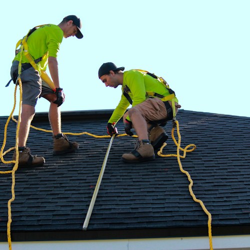 Repair crew working on residential roof, replacing flashing