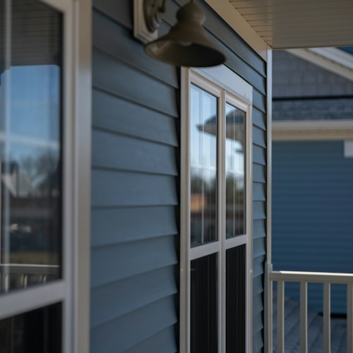 New siding installation, blue vinyl siding with white trim