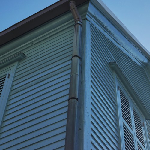 Gutter and downspout installation on a colonial home