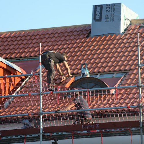 Storm damage repair, roofer assessing post-hail damage